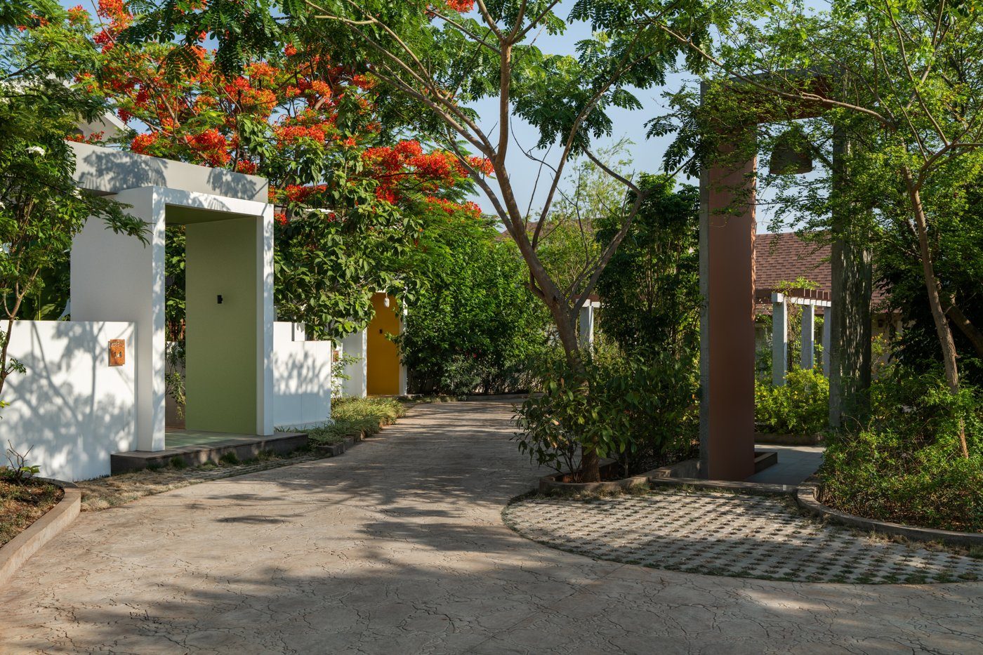 Landscaped pedestrian street between low villas with a gateway