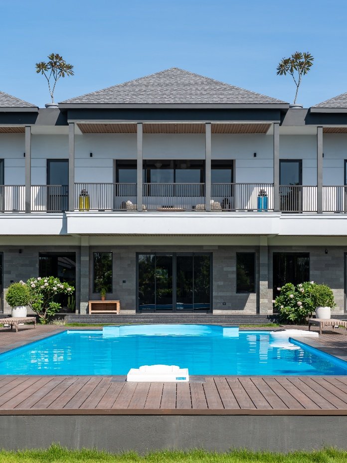 Double-height villa elevation overlooking a swimming pool