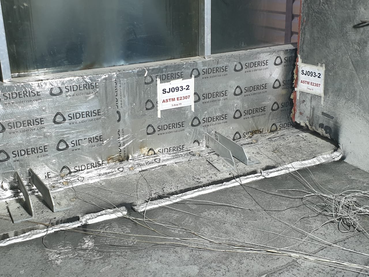 Before the burners. A perimeter firestop built as it will be tested, which is the only version of it the certificate covers.