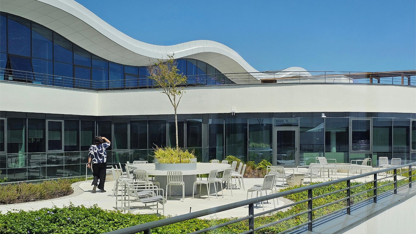 People on a landscaped rooftop terrace with city views