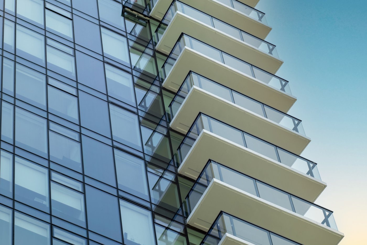 Aligned, and cheapest. Running the stack joint round the building at one level is the lowest-cost, lowest-risk arrangement for balconies, and the first thing Hubbs recommends.