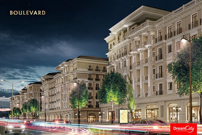 A lit classical street of apartment blocks with shops and cafés at pavement level