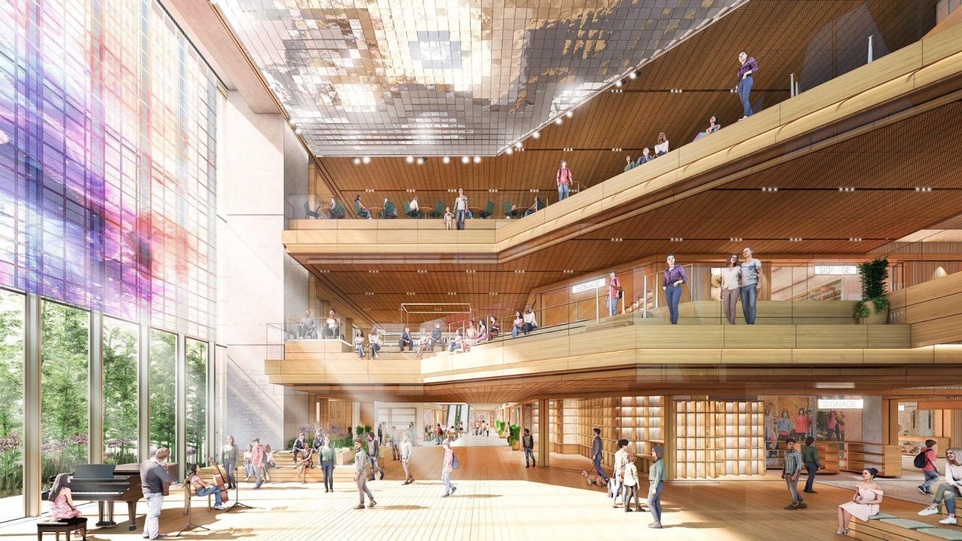 A living room for the neighbourhood. Seating on the atrium edges overlooks the floor below, and a translucent photovoltaic screen adds movement without closing off the mountain view.