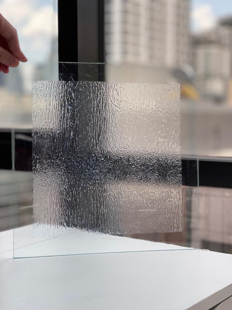 Peeled off at handover. A film protecting glass and aluminium through construction for twelve to fifteen months, where conventional protection lasts weeks.