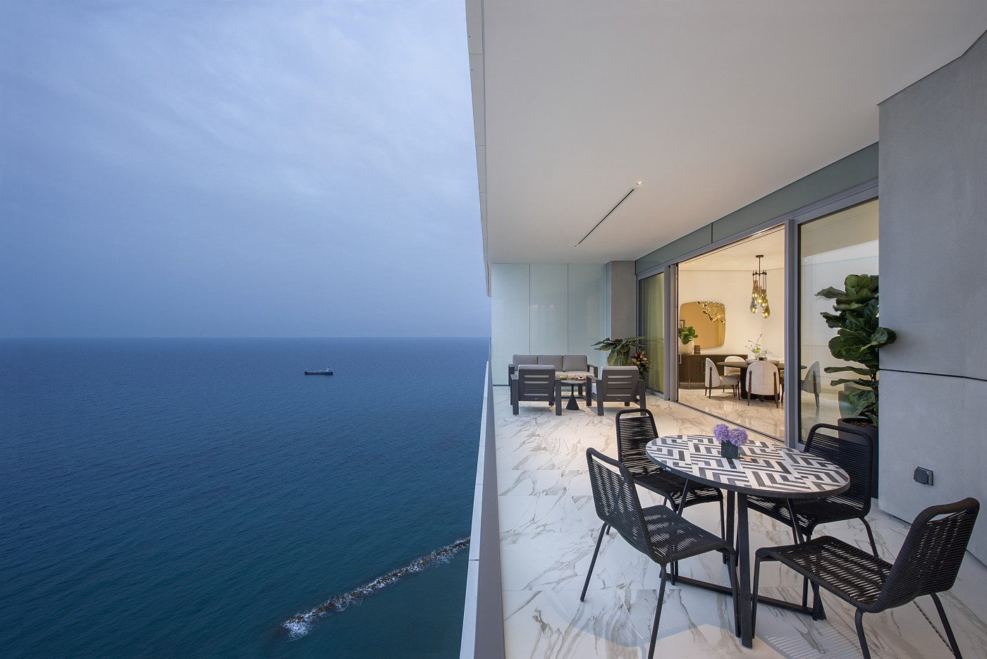 Not a rendering. The terrace as a living space suspended between city, sky and sea, where the façade is designed to disappear and leave the horizon.