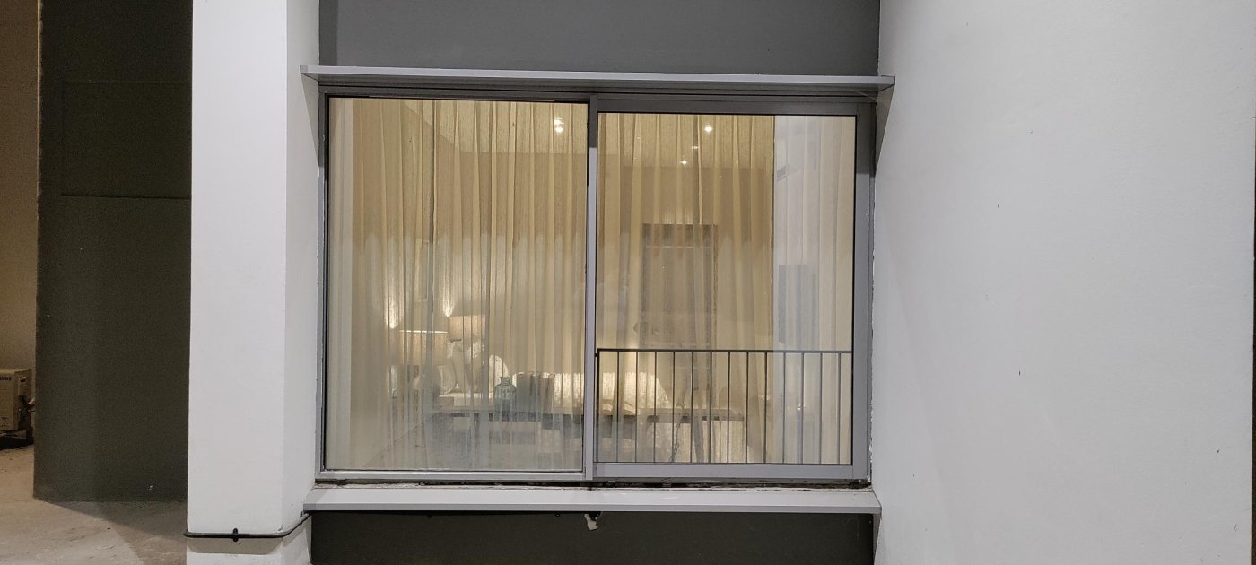Not quite a balcony. The railing across the opening gave the occupant the feel the brief asked for, and created the drainage problem that followed.