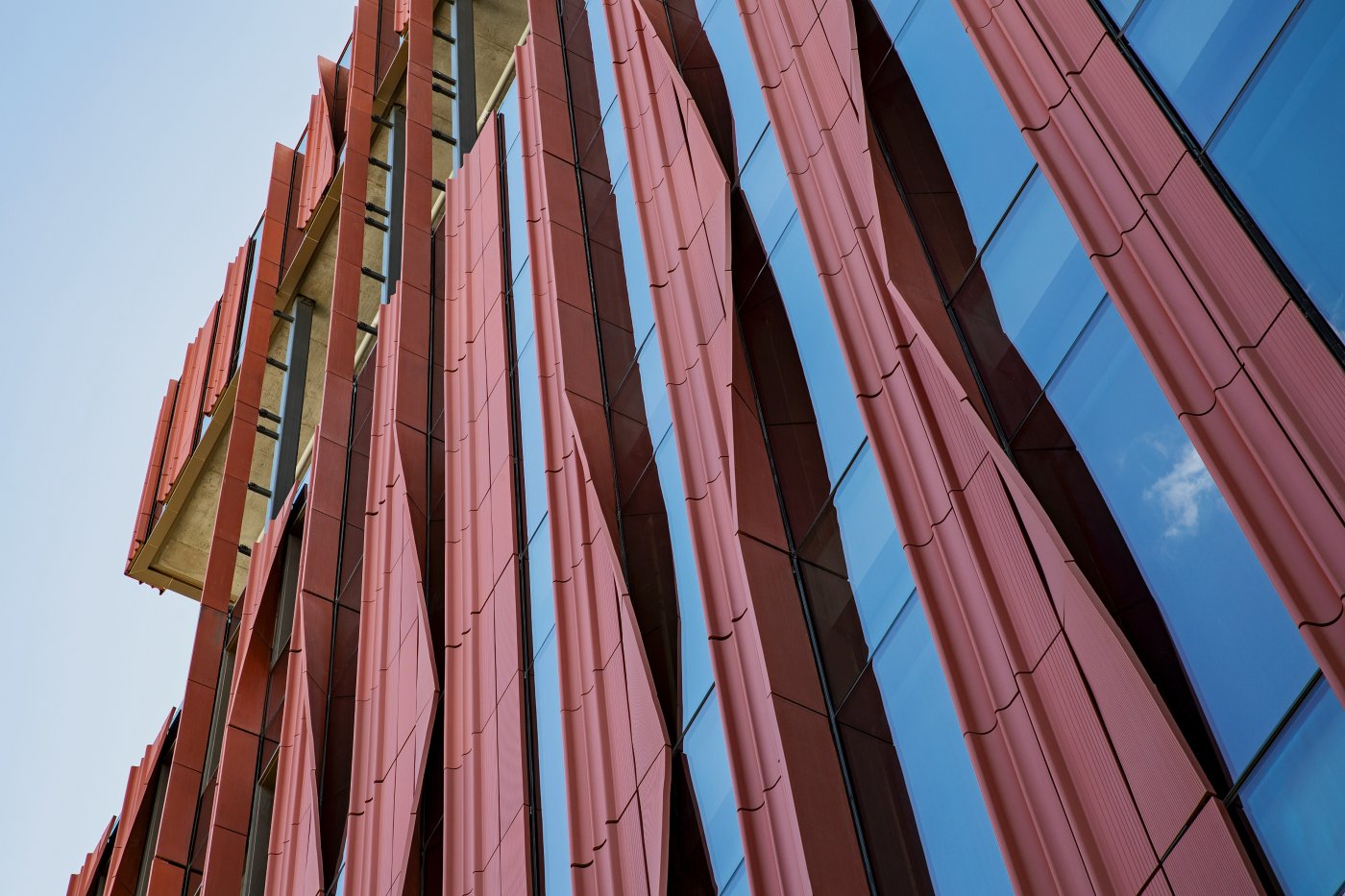 Extruded, then bent. Schwartz said 12 by 60 inch panels were extruded and, while still malleable, bent and twisted into shape before being integrated into unitised curtain wall.