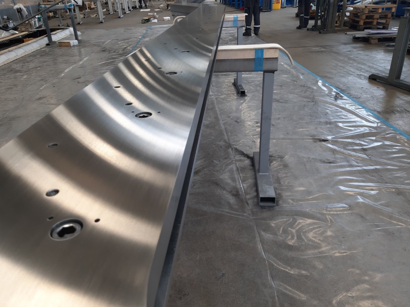 Drilled to take the glass. The stringer was limited to a few hundred millimetres, so the balustrade had to become part of the beam.
