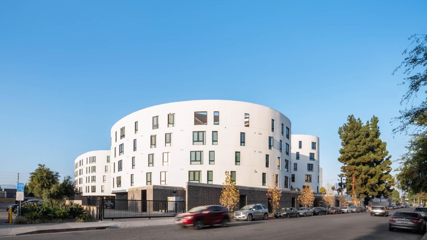 Curved white housing blocks around a landscaped courtyard