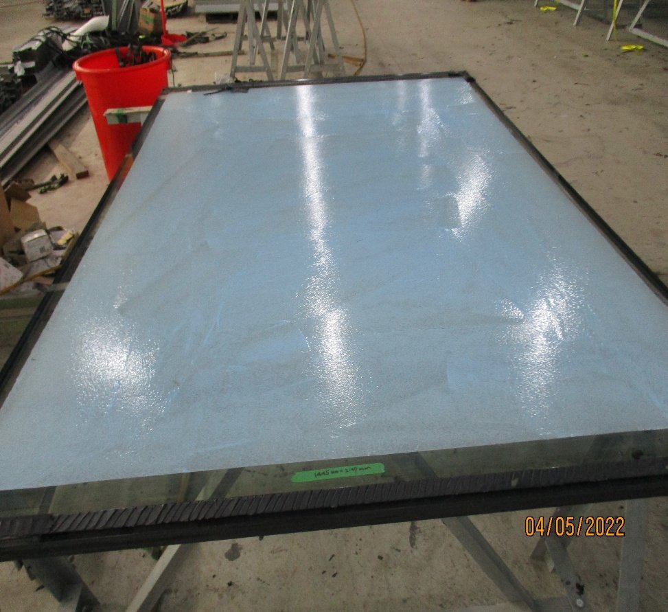 Bonded while bent. The frame is pre-bent and the glass bent as it is bonded, so the sealant carries the bending load and then the wind.