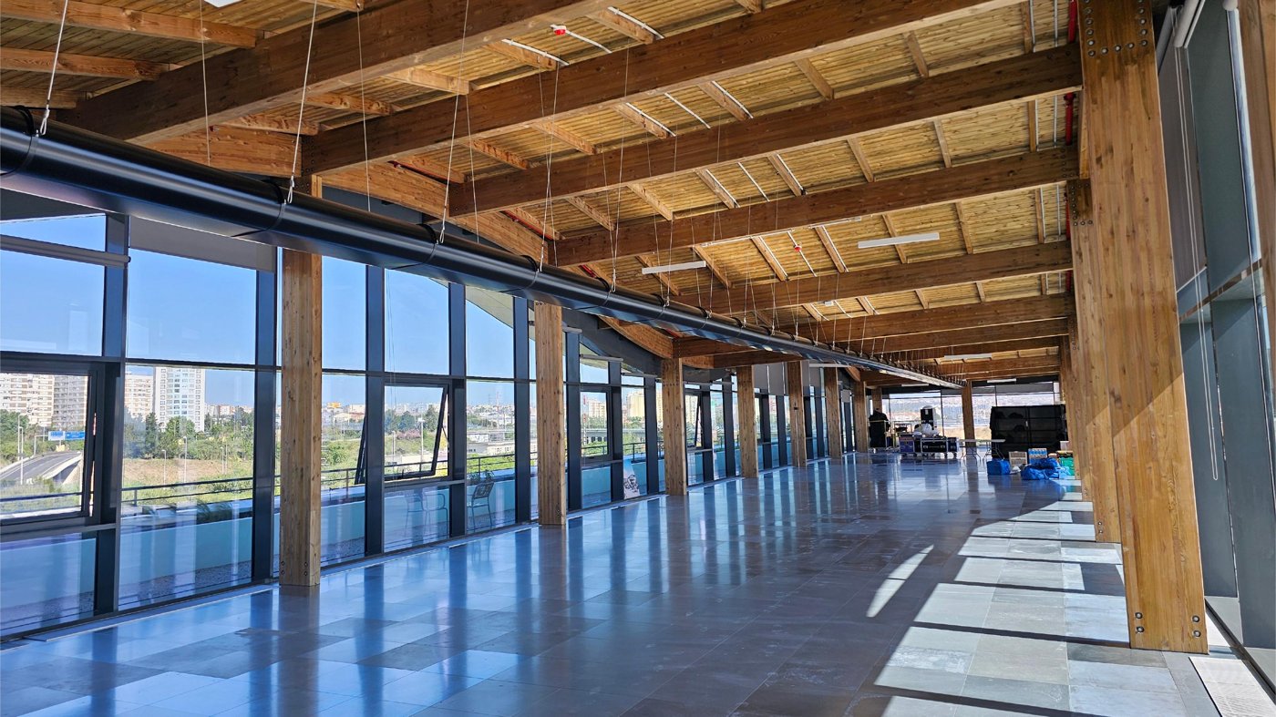 Wood-lined interior office opening onto a planted terrace