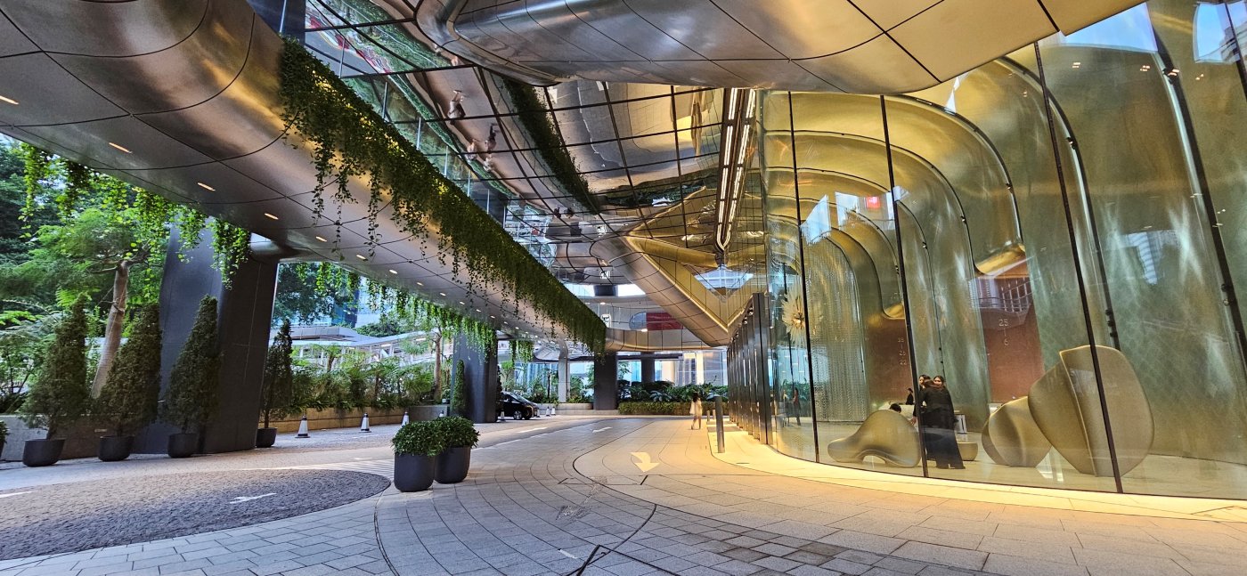 Eleven metres at the lobby. A carrier frame lets a pane be exchanged with no structural sealant anywhere in the system.