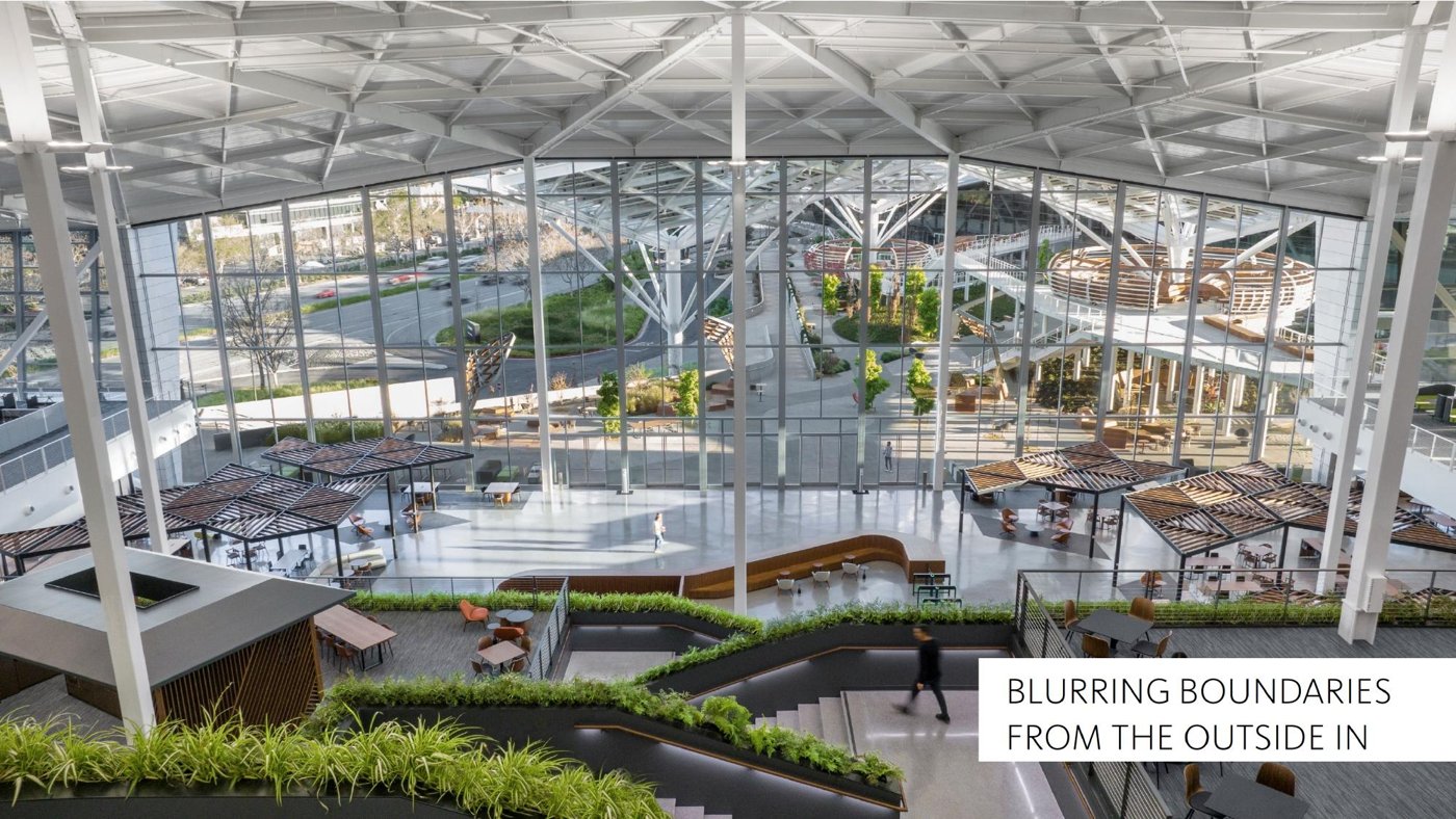 Planted, top-lit interior atrium beneath an angular roof